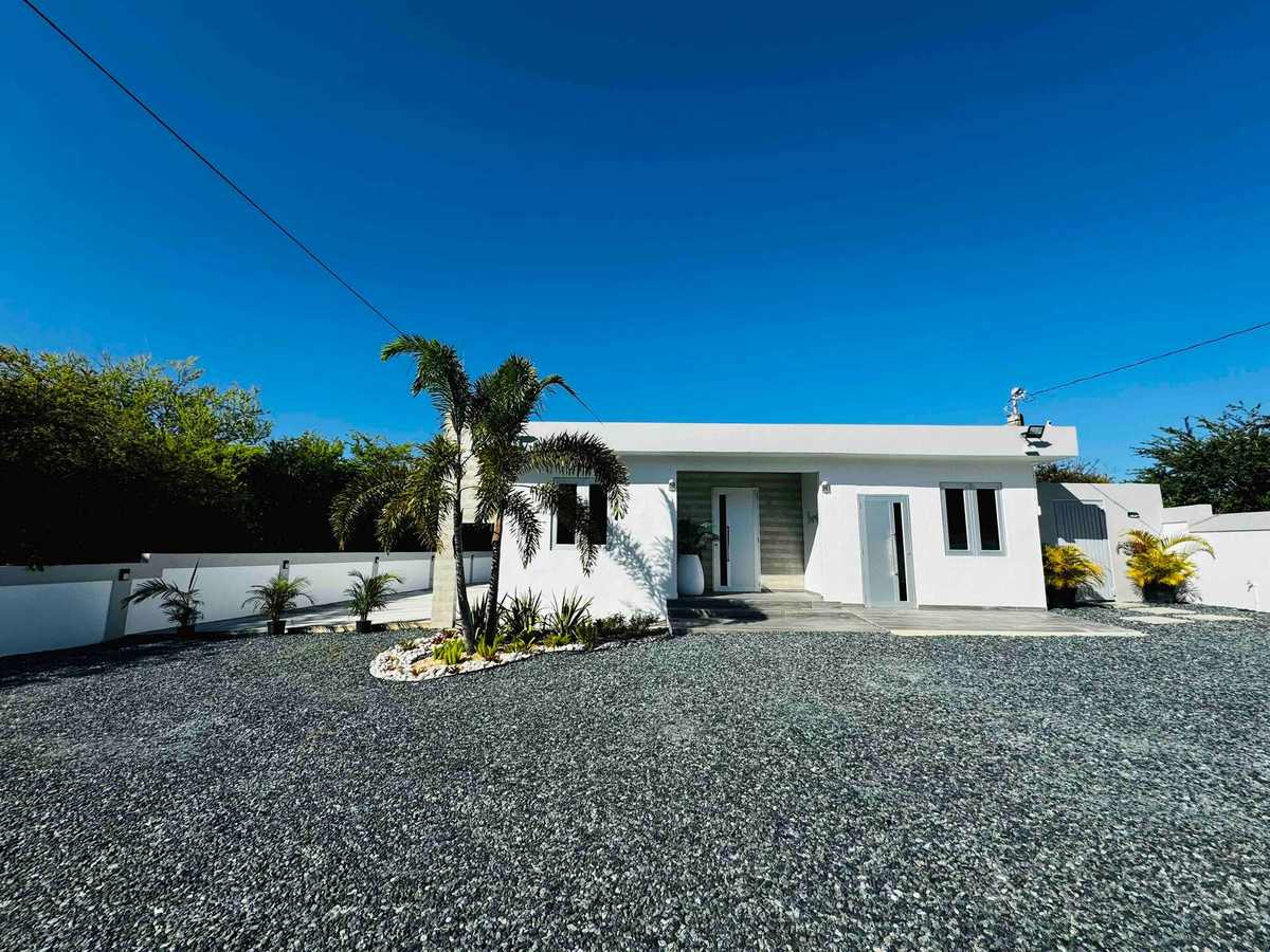Fachada blanca moderna bajo un cielo azul brillante