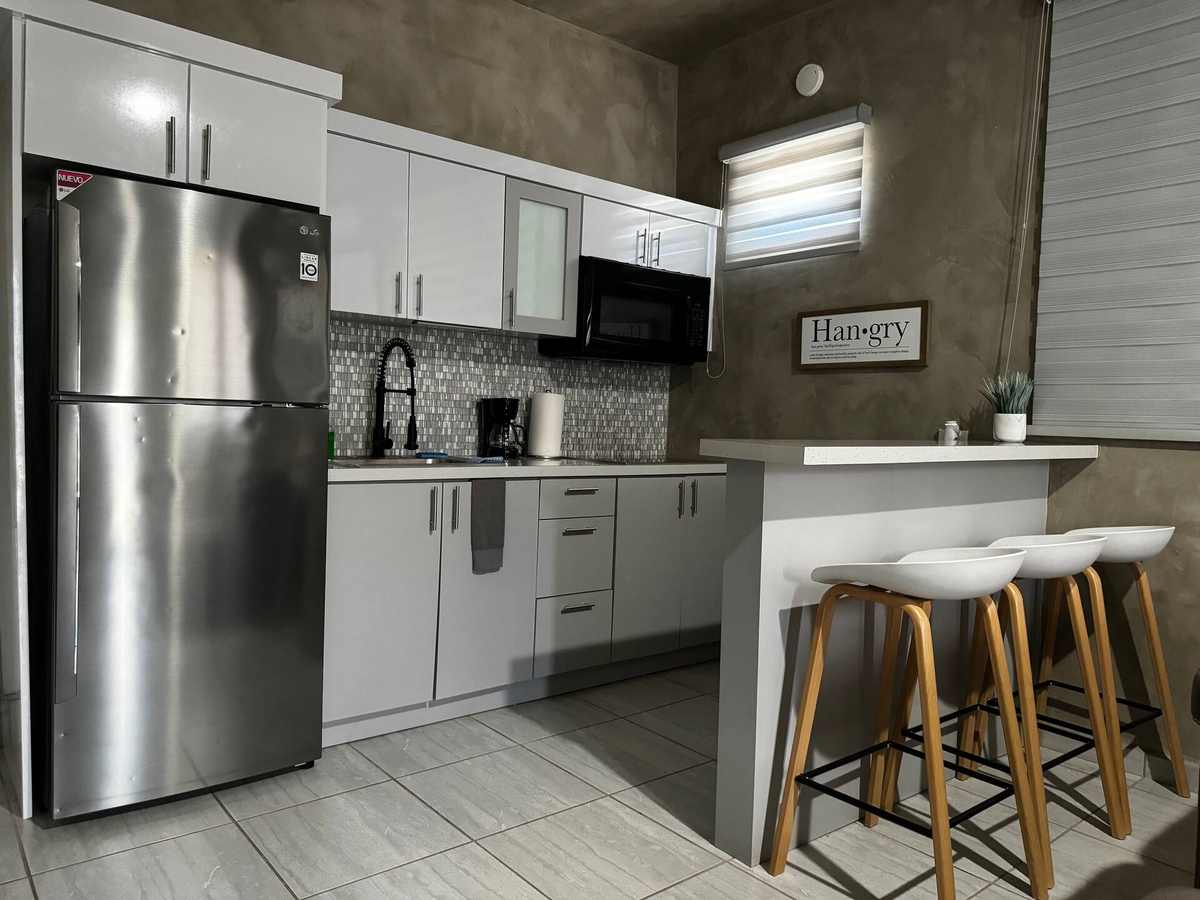 Cocina con enseres de acero inoxidable y barra de desayuno