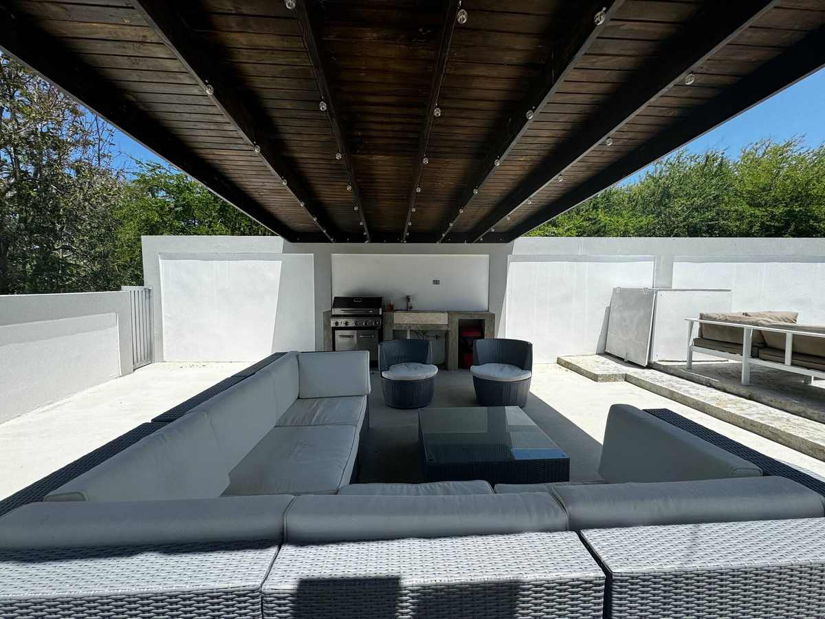 Sala de estar en la azotea bajo una pérgola